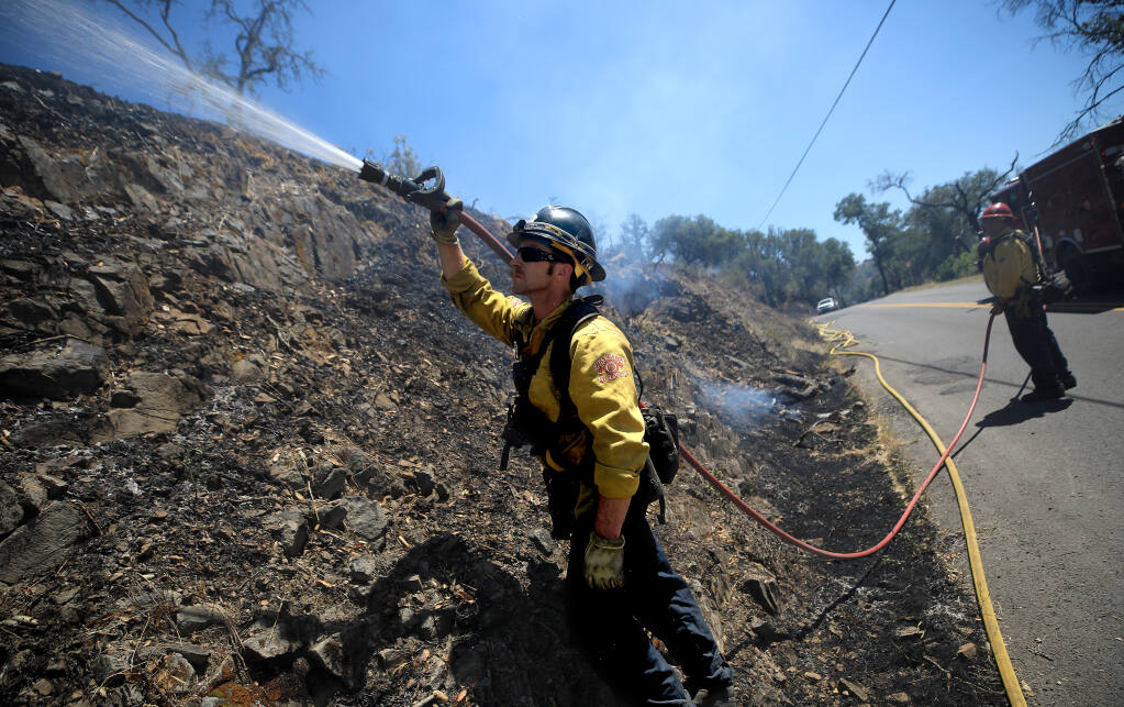 Hayward Fire Department firefighter Jim Lauglin works to put out a spot fire, Wednesday, June 1, 2022 on the Old fire in Napa County. (Kent Porter / The Press Democrat) 2022