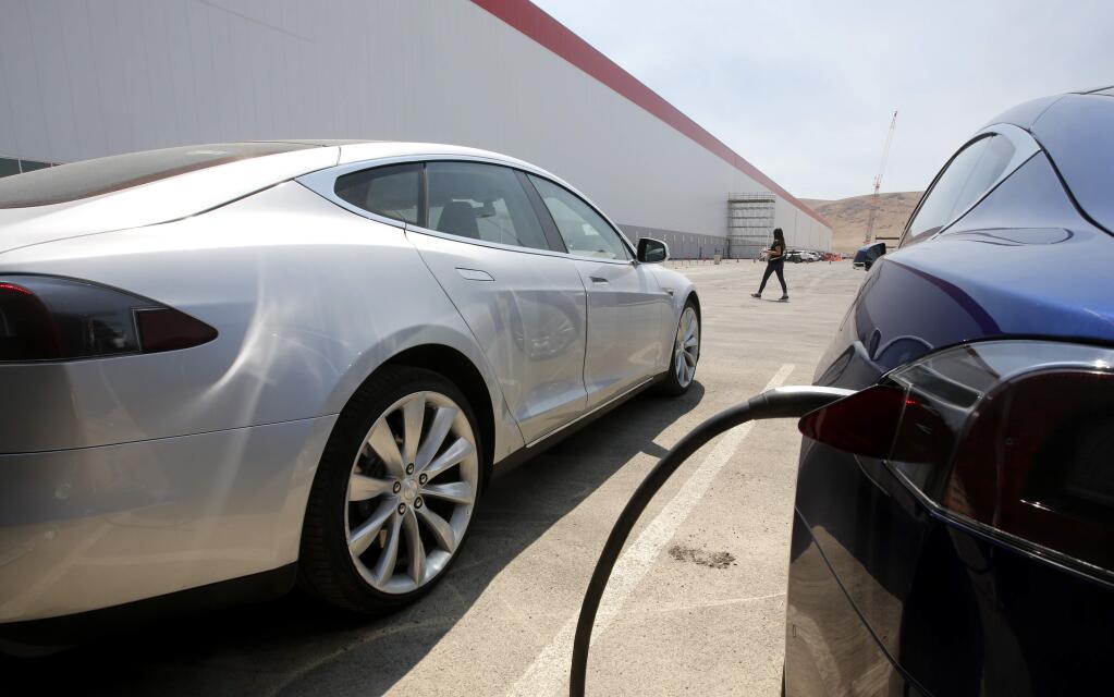 Tesla Motors model S cars are charged at the new Tesla Gigafactory, Tuesday, July 26, 2016, in Sparks, Nev. The Gigafactory is Tesla Motors' biggest bet yet: A massive, $5 billion factory in the Nevada desert that could almost double the world's production of lithium-ion batteries by 2018. (AP Photo/Rich Pedroncelli)