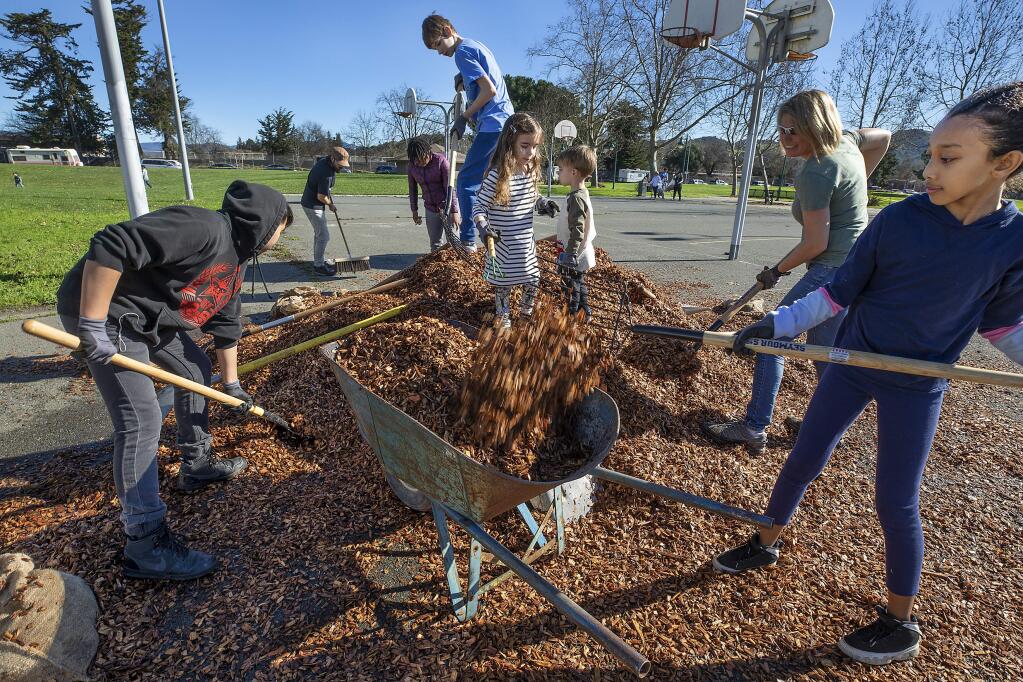 Volunteers load a wheelbarrow with mulch during a workday on Martin Luther King Jr. Day in Martin Luther King Jr. park in Santa Rosa on Monday. (photo by John Burgess/The Press Democrat)