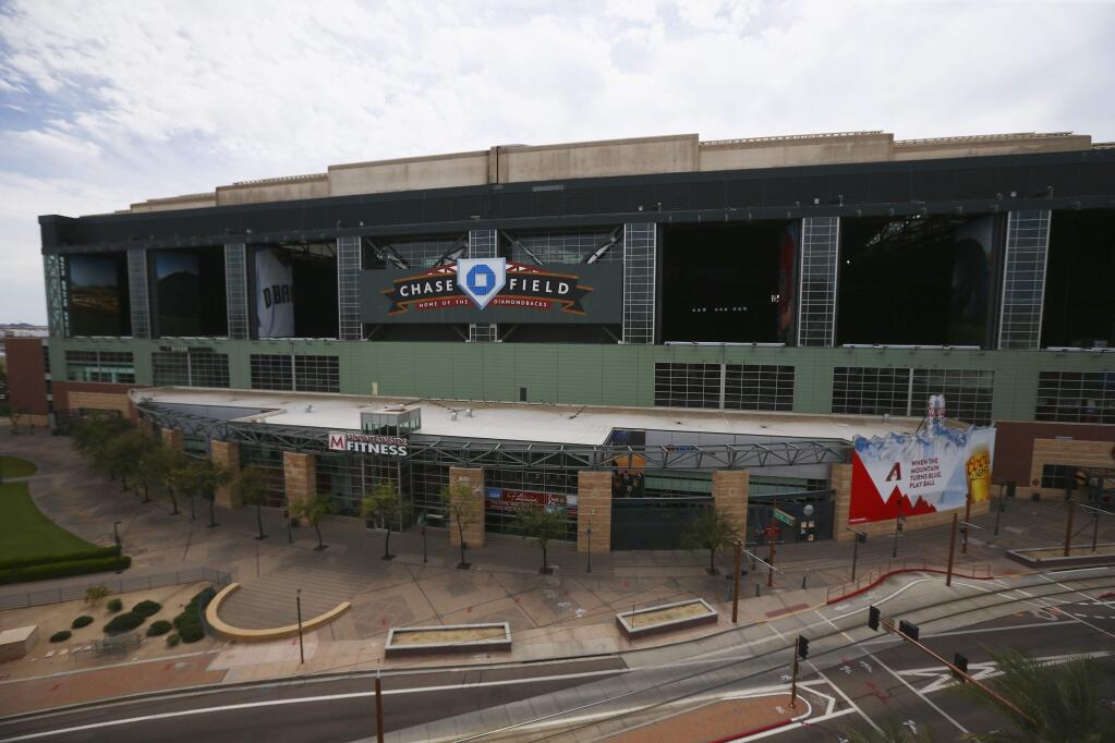 This Thursday, March 26, 2020 file photo shows Chase Field in Phoenix, the home of the Arizona Diamondbacks, which has been empty because of the coronavirus pandemic as the baseball season was shut down. Putting all 30 teams in the Phoenix area this season and playing in empty ballparks was among the ideas discussed Monday, April 6, 2020 during a call among five top officials from MLB and the players' association that was led by Commissioner Rob Manfred, people familiar with the discussion told the Associated Press. (AP Photo/Ross D. Franklin, File)