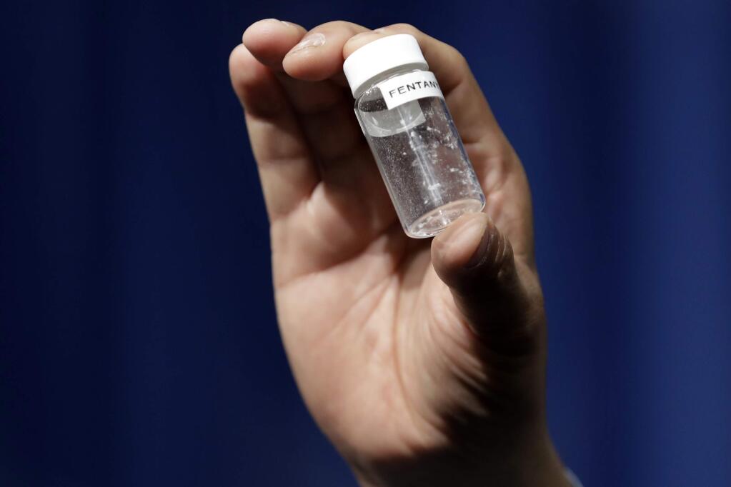 FILE - In this June 6, 2017, file photo, a reporter holds up an example of the amount of fentanyl that can be deadly after a news conference about deaths from fentanyl exposure. (JACQUELYN MARTIN/ASSOCIATED PRESS)