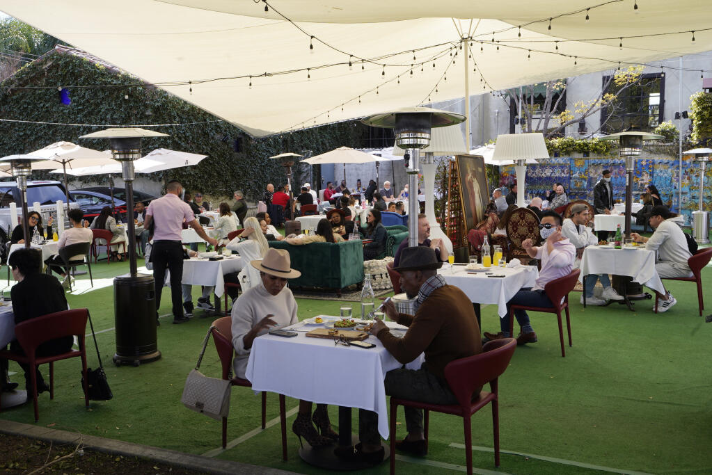 FILE - In this Feb. 14, 2021, file photo, people dine under a tent outside a restaurant in West Hollywood, Calif.  (AP Photo/Damian Dovarganes, File)