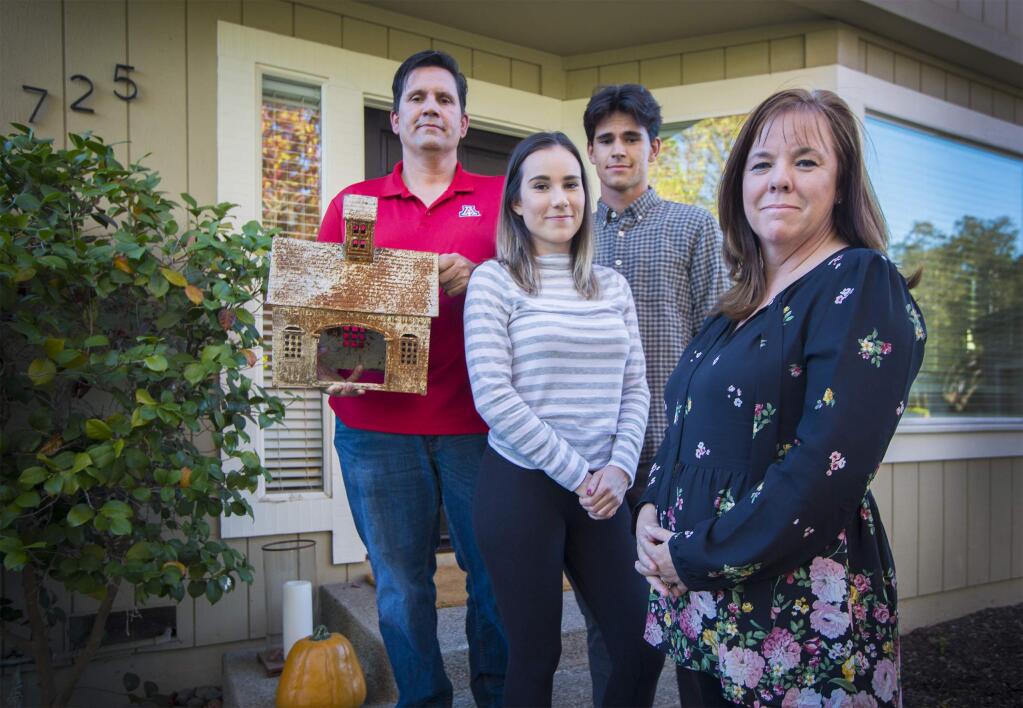 Local Real Estate Agent Erin George with her family - husband Joe, daughter Jacqueline and son Nick. Joe is holding the one item that survived the firestorm and destroyed their Santa Rosa house - a decorative metal barn. (Photo by Robbi Pengelly/Index-Tribune)