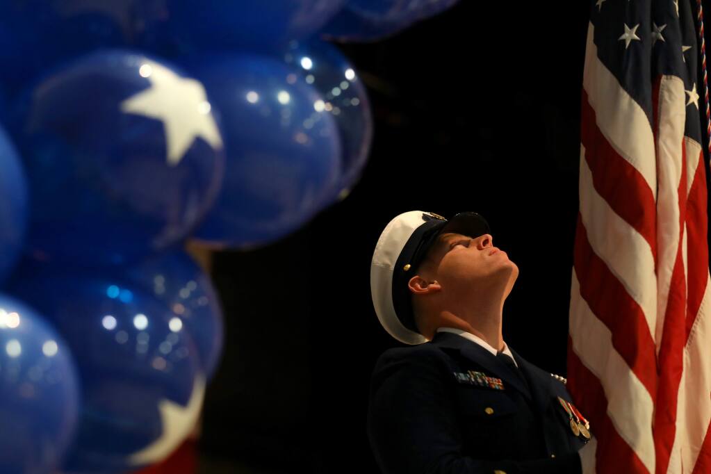 Coast Guard color guard member Curtis Salisbury removes the American flag at the end of a lunch honoring veterans at the Santa Rosa Veterans Memorial Building in Santa Rosa on Thursday, November 7, 2019. (BETH SCHLANKER/ The Press Democrat)