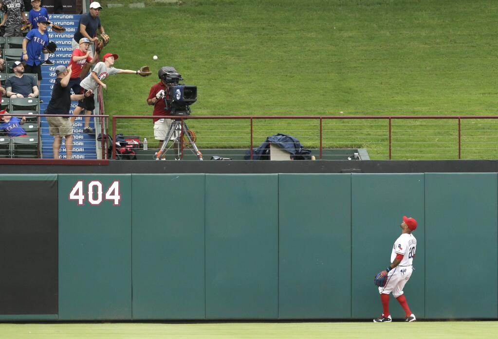 Texas Rangers center fielder Ian Desmond (20) watches the home run hit by Oakland Athletics Danny Valencia clear the fence during the first inning of a baseball game in Arlington, Texas, Monday, July 25, 2016. (AP Photo/LM Otero)
