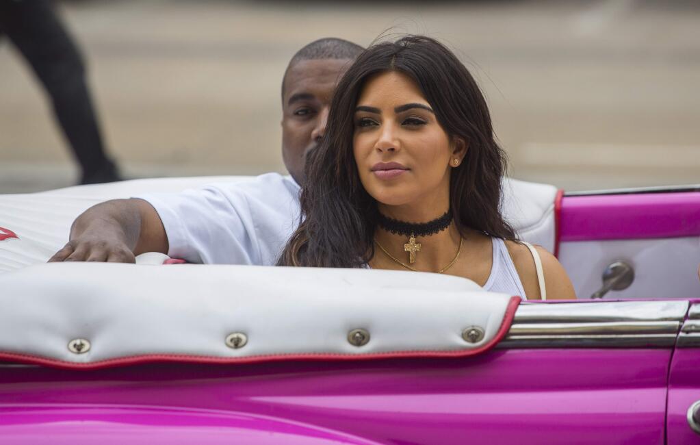 American reality-show star Kim Kardashian West and her husband, rap superstar, Kayne West ride on a classic car in Havana, Cuba, Wednesday, May 4, 2016. West, Kardashian and members of her reality-show-star family have become the latest celebrities to visit Havana. They visited Havanas Museum of Rum Wednesday, stepping out of a hot-pink antique American convertible as they snapped selfies and were recorded by a television crew following them around.(AP Photo/Desmond Boylan)
