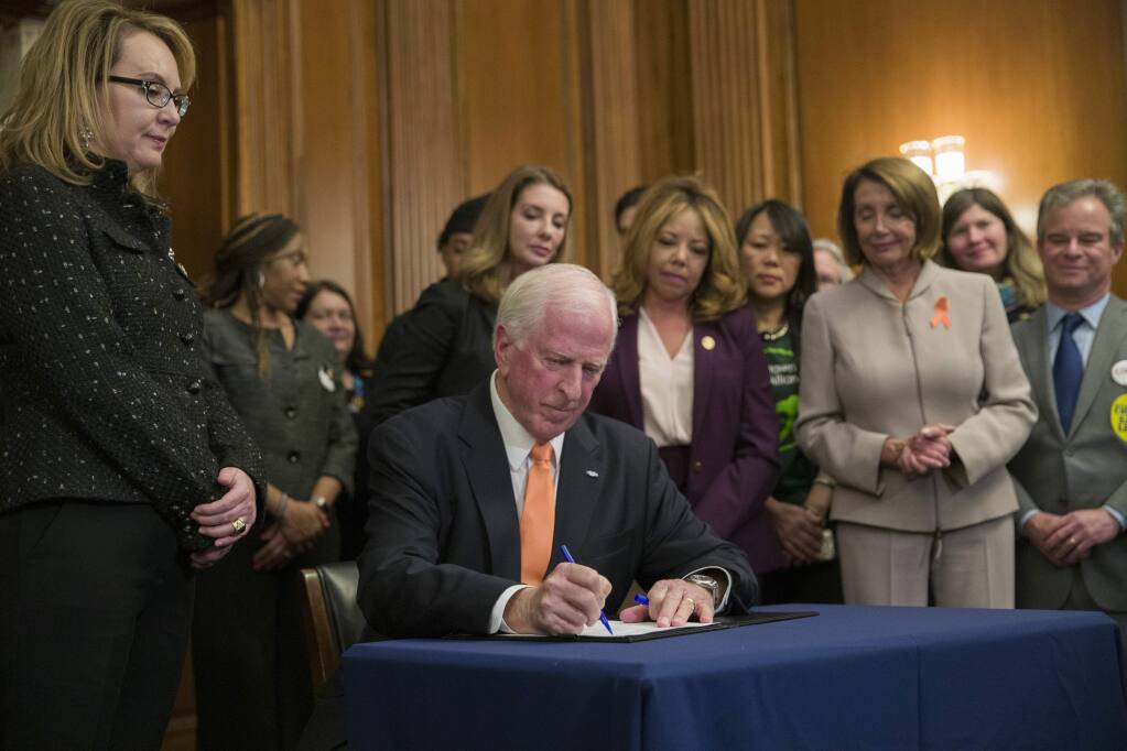 House Speaker Nancy Pelosi of Calif., right, watches as Gun Violence Prevention Task Force Chairman fellow Democratic Rep. Mike Thompson, D-Calif., signs the bill, accompanied by gun violence victim former Rep. Gabby Giffords, right, and others, during a news conference to announce introduction of bipartisan legislation to expand background checks for sales and transfers of firearms, on Capitol Hill, Tuesday, Jan. 8, 2019 in Washington. (AP Photo/Alex Brandon)