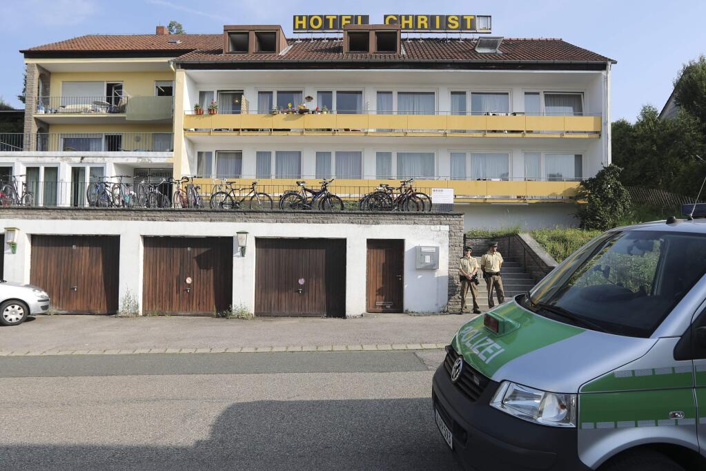 Police officers secure a former hotel where a Syrian man lived before the explosion in Ansbach, Germany, Monday, July 25, 2016. Bavaria's top security official says a man who blew himself up after being turned away from an open-air music festival in the southern German city was a 27-year-old Syrian who had been denied asylum. (AP Photo/Matthias Schrader)