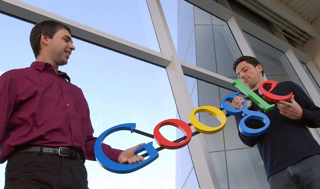 In this Jan. 15, 2004 file photo, Google co-founders Larry Page, left, and Sergey Brin pose for photos at their company's headquarters in Mountain View, Calif. Google's IPO 10 years ago launched the company on a trajectory that continues to reshape its business and much of the world in its orbit. (AP Photo/Ben Margot, File)