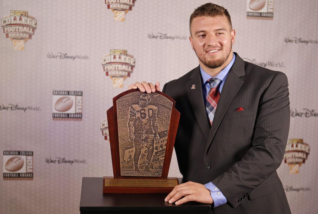 Arizona linebacker Scooby Wright, a graduate of Cardinal Newman High School, poses with the Chuck Bednarik Award, which he received at Lake Buena Vista, Fla., in December as college football's defensive player in 2014. Wright is projected already be among the first-round selections in the 2016 NFL Draft. (John Raoux / Associated Press)