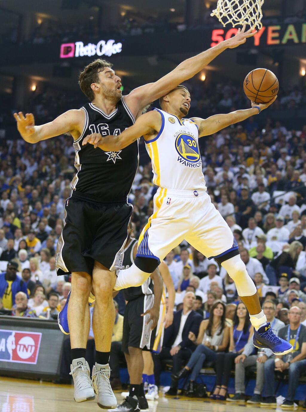 Golden State Warriors guard Stephen Curry is fouled by San Antonio Spurs forward Pau Gasol as he goes to the basket, during their game in Oakland on Tuesday, October 25, 2016. (Christopher Chung/ The Press Democrat)