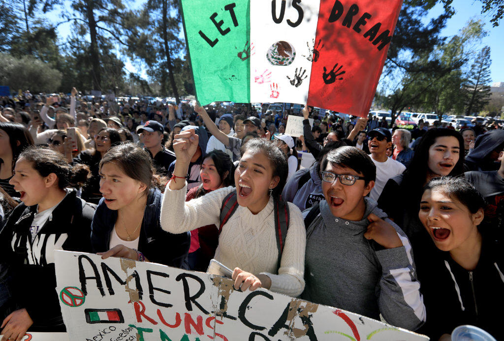 Roseland University Prep students Gisele Hernandez, middle, and her sister Anahy Hernandez, left, join Angel Sanchez, right, as over a thousand protesters show support for undocumented immigrants in Santa Rosa, Monday March 5, 2018 as they stopped at the Federal building on a march through downtown Santa Rosa in a public display of support for undocumented immigrants. (Kent Porter / Press Democrat) 2018