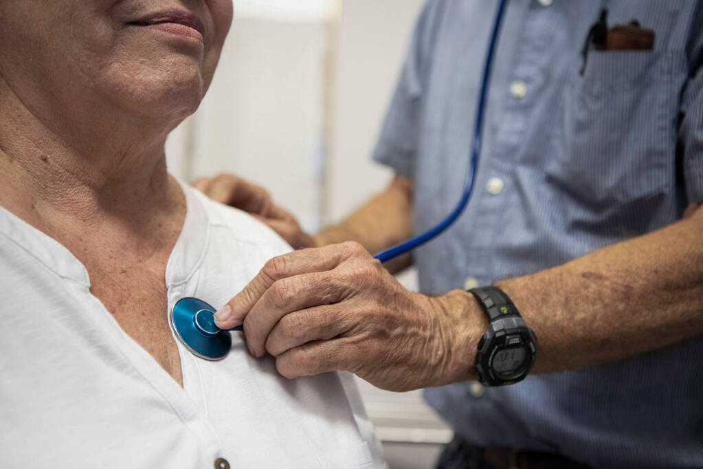 A doctor listens to a patient's heartbeat at the Mountain Valley Health Center in Bieber on July 24, 2019. Photo by Anne Wernikoff for CalMatters