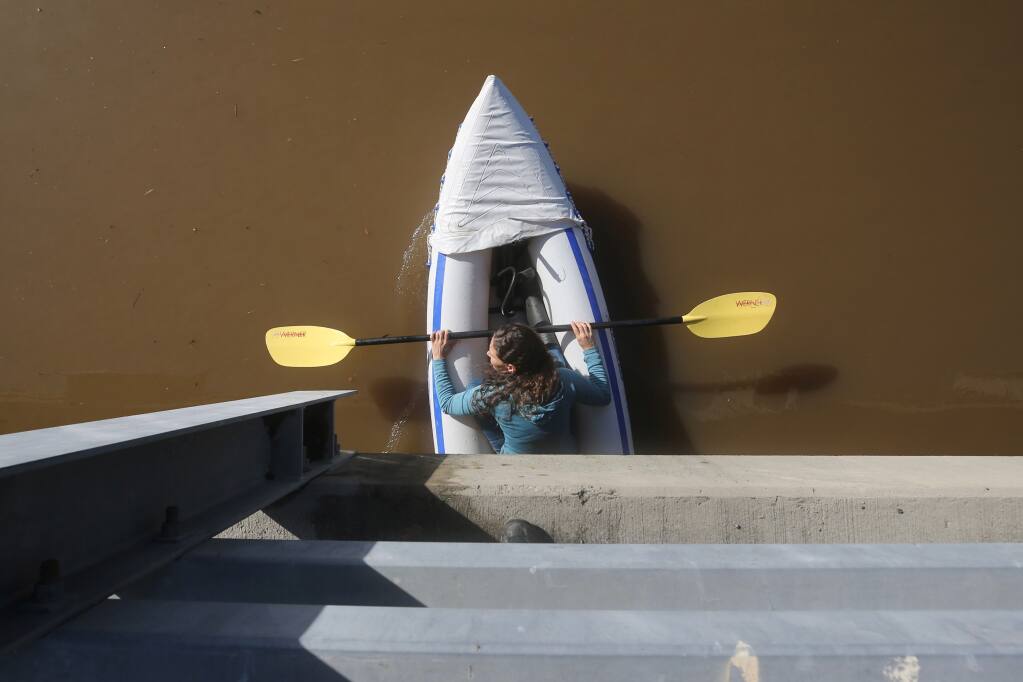 A woman floats under the bridge on Occidental Road in the Laguna de Santa Rosa on Monday, Oct. 25, 2021. (Beth Schlanker / The Press Democrat)