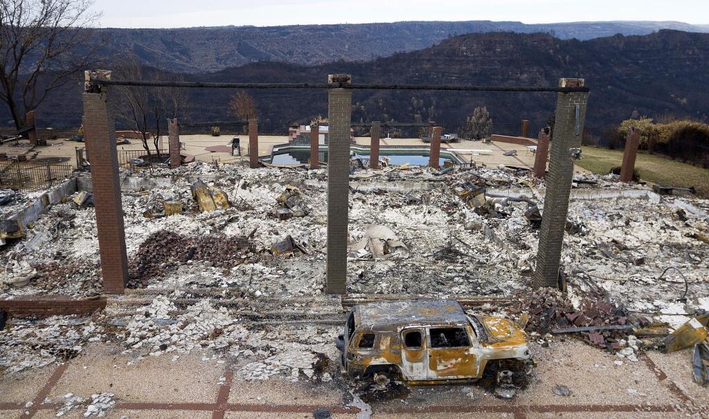 A vehicle rests in front of a home leveled by the Camp Fire in Paradise, Calif., on Monday, Dec. 3, 2018. (AP Photo/Noah Berger)