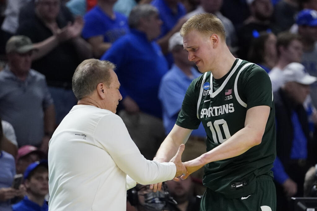 Michigan State forward Joey Hauser shakes hands with head coach Tom Izzo as he leaves the court during their loss against Duke in a college basketball game in the second round of the NCAA tournament on Sunday, March 20, 2022, in Greenville, S.C. (AP Photo/Chris Carlson)