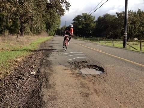 A cyclist negotiates a pothole on one of Sonoma Countys crumbling roads. (SUBMITTED BY CRAIG HARRISON)