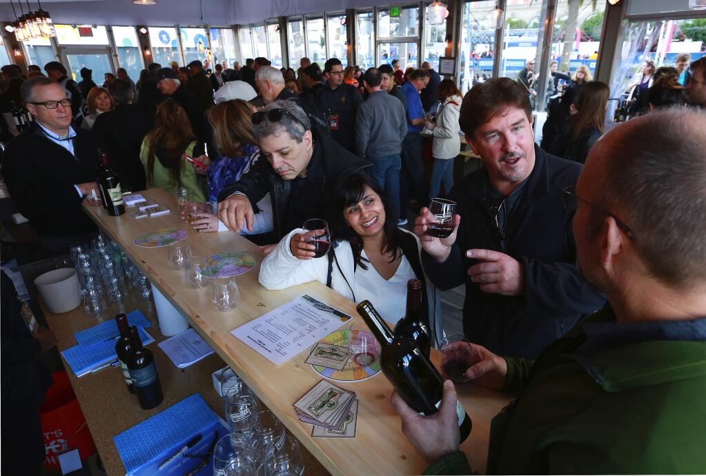Scot Covington, right, with Trione Winery pours samples for Ed Temple of Fremont and Sangi Maheshwari of Cupertino at the Sonoma County wine and tourism tent at Super Bowl City in San Francisco. (JOHN BURGESS/ PD FILE, 2015)
