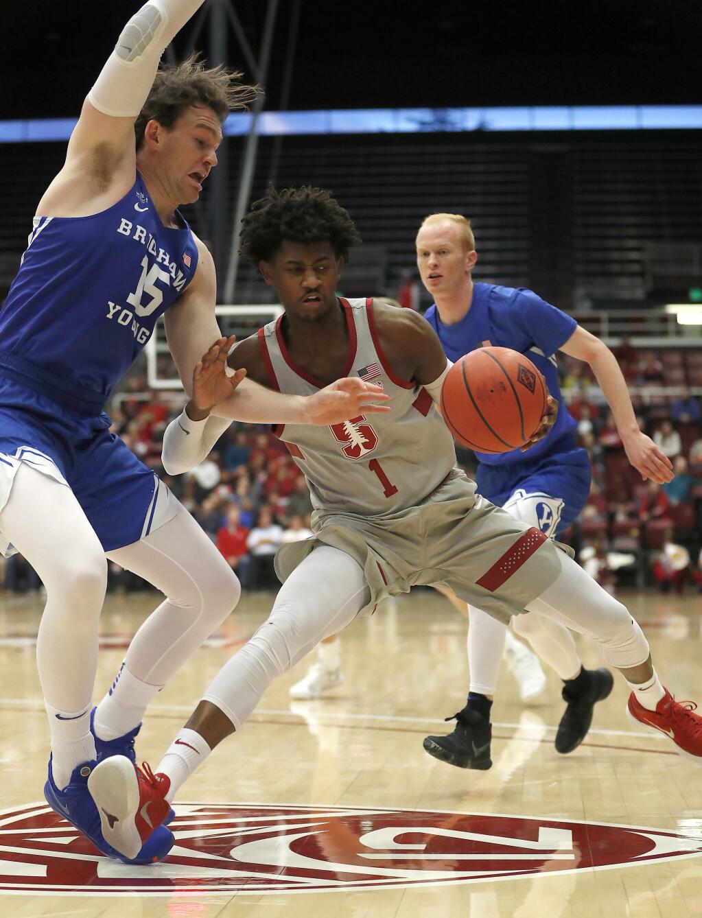 Stanford guard Daejon Davis (1) drives against BYU forward Payton Dastrup (15) during the first half in the first round of the NIT on Wednesday, March 14, 2018, in Stanford. (AP Photo/ Tony Avelar)