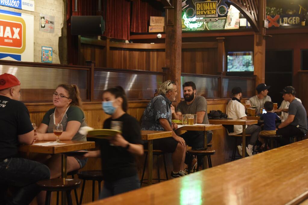 Guests seating is divided by empty tables to provide social distancing in the bar area at Russian River Brewing Company in downtown Santa Rosa, Calif., on Thursday, July 2, 2020. (Erik Castro/For The Press Democrat)