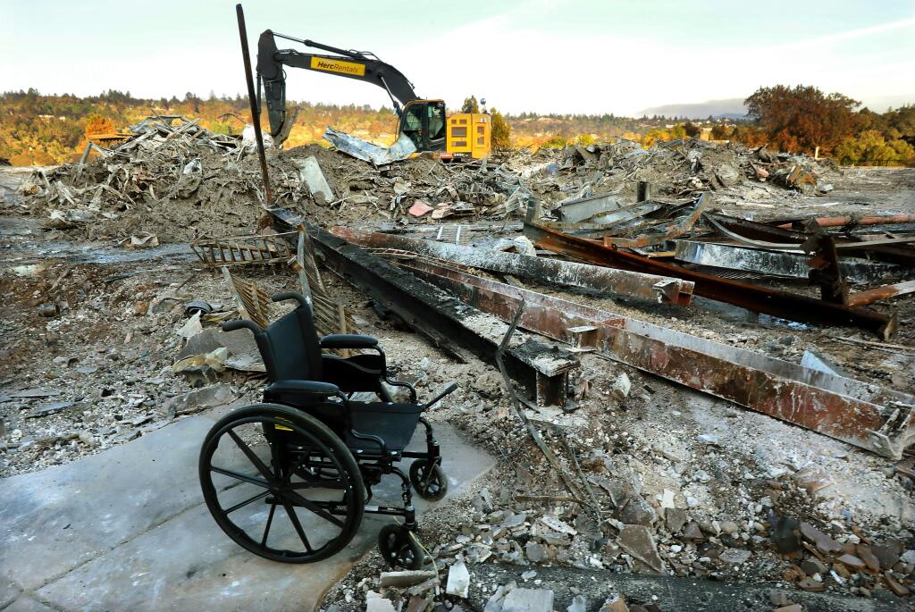 A wheelchair sits amidst the rubble of Oakmont of Villa Capri, the assisted living and memory care unit in the Fountaingrove senior facility in Santa Rosa. The facility is being investigated by the Dept. of Social Services for allegedly leaving behind residents when staff evacuated during the Tubbs fire. (photo by John Burgess/The Press Democrat)