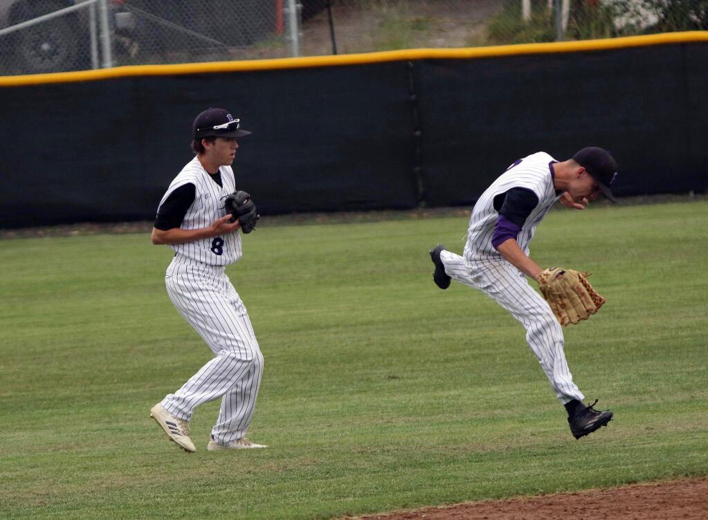 DWIGHT SUGIOKA/FOR THE ARGUS-COURIERPetaluma outfielders Sam Jacobs and Kempton Brandis chase down the ball in the Trojans' NCS game against El Cerrito.