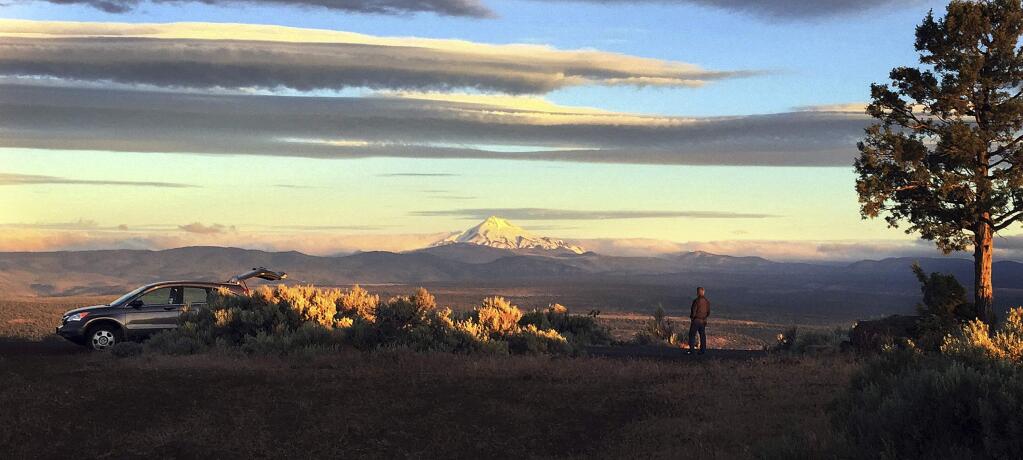 Joe Krenowicz, executive director of the Madras-Jefferson County Chamber of Commerce, looks toward Mt. Jefferson as the sun rises over Madras, Oregon on June 13, 2017. The first place to experience total darkness as the moon passes between the sun and the Earth will be in Oregon and Madras, in the central part of the state, is expected to be a prime viewing location. Up to 1 million people are expected in Oregon for the first coast-to-coast total solar eclipse in 99 years and up to 100,000 could show up in Madras and surrounding Jefferson County. Officials are worried about the ability of the rural area to host so many visitors and are concerned about the danger of wildfire from so many people camping on public lands. (AP Photo/Gillian Flaccus)