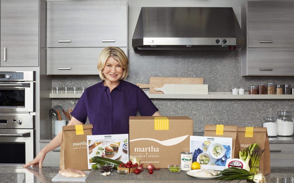 In this photo provided by Marley Spoon, Inc., Martha Stewart poses with ingredients from a meal kit. Cooking like Stewart is about to get easier, as the home goods mogul and cookbook author is getting into the fast-growing meal kit business. Subscribers of the meal kits will be shipped a box to their doors with Stewart's recipes and all the ingredients needed to cook up the dishes at home, including pre-measured raw meat, fish, vegetables and spices. The new venture is a licensing deal with existing meal kit company Marley Spoon and brand management company Sequential Brands Group Inc., which bought Martha Stewart Living Omnimedia in 2015. (Marcus Nilsson/Courtesy of Marley Spoon, Inc. via AP)