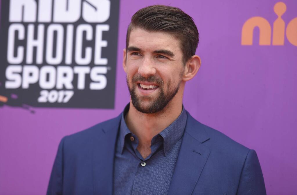 FILE - In this July 13, 2017 file photo, retired Olympic swimmer Michael Phelps arrives at the Kids' Choice Sports Awards at UCLA's Pauley Pavilion in Los Angeles. Discovery Channel's Shark Week's opening lineup Sunday, July 23, includes 'Phelps vs. Shark: Great Gold vs. Great White,' with Phelps testing his speed against that of a great white shark. (Photo by Richard Shotwell/Invision/AP, File)