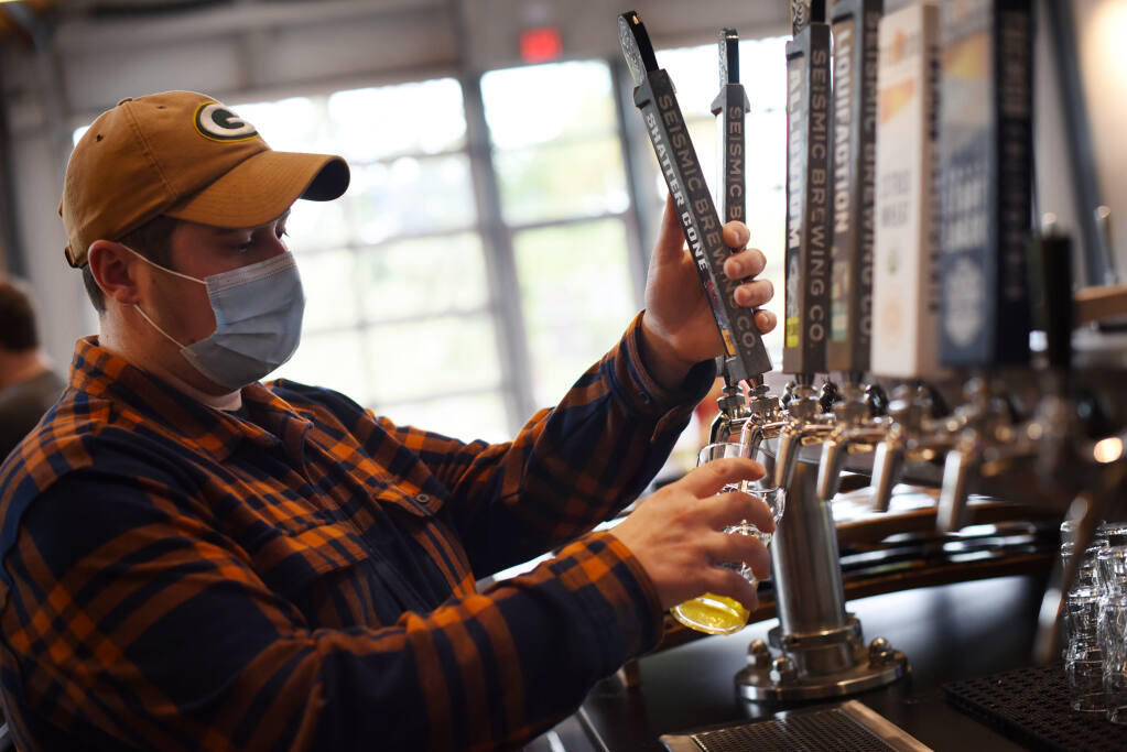 Korey Smith pours an IPA at Seismic Brewing taproom in The Barlow in Sebastopol, Calif., on Thursday, Oct. 7, 2021. (Erik Castro / For The Press Democrat)