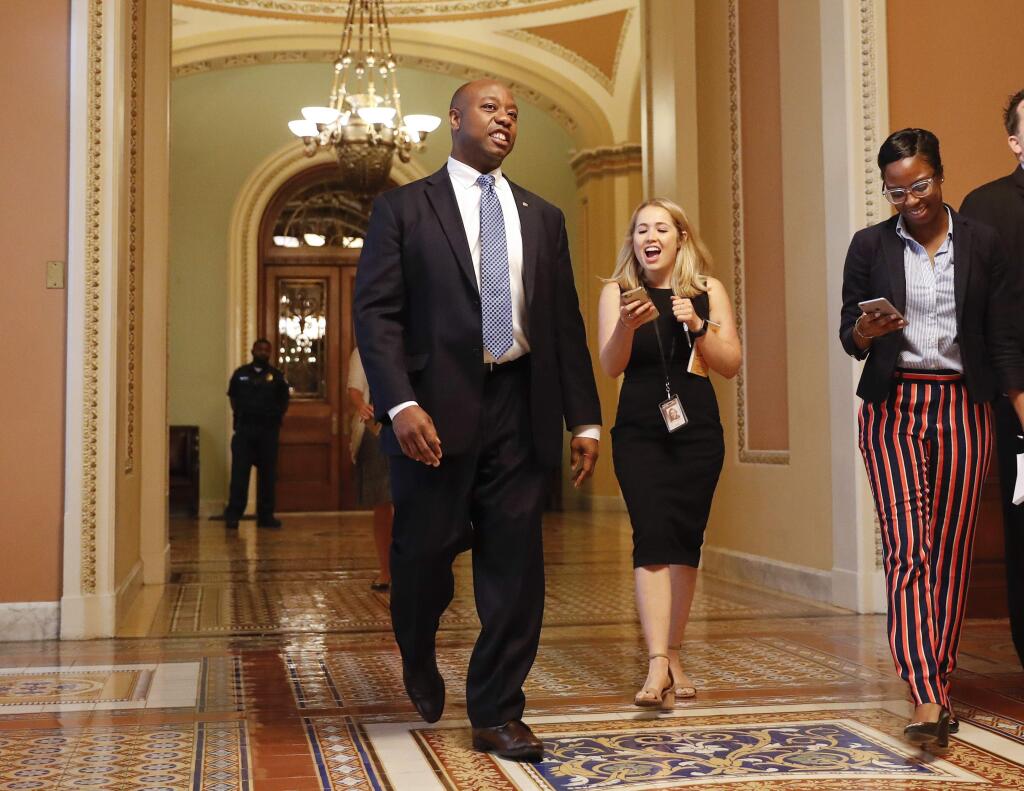 Sen. Tim Scott, R-S.C., walks in a hallway to a meeting on Capitol Hill in Washington Thursday, July 13, 2017. Senate Majority Leader Mitch McConnell of Ky. plans to roll out the GOP's revised health care bill, pushing toward a showdown vote next week with opposition within the Republican ranks. (AP Photo/Pablo Martinez Monsivais)