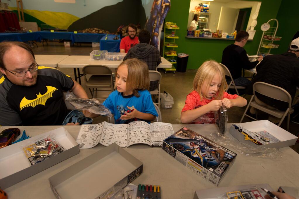 Matt Herman of Petaluma, watches his sons, Vonn, 7, and Xander, 6, right, as they build a robot called 'Gundam' at Fundemonium in Rohnert Park, Calif., on Saturday, October 21, 2017. (Photo by Darryl Bush / For The Press Democrat)