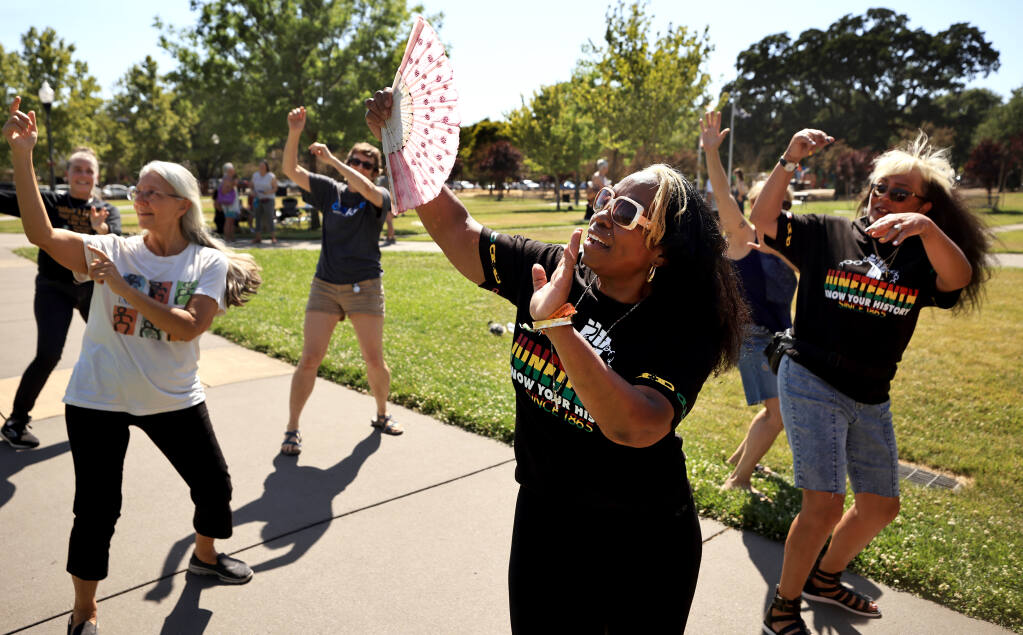 Sisters, Sabra Locke, middle, and Sydni Davenport, right, of Santa Rosa, lead a dance  during the Juneteenth celebration on the Windsor Town Green, Saturday, June 19, 2021. (Kent Porter / The Press Democrat) 2021