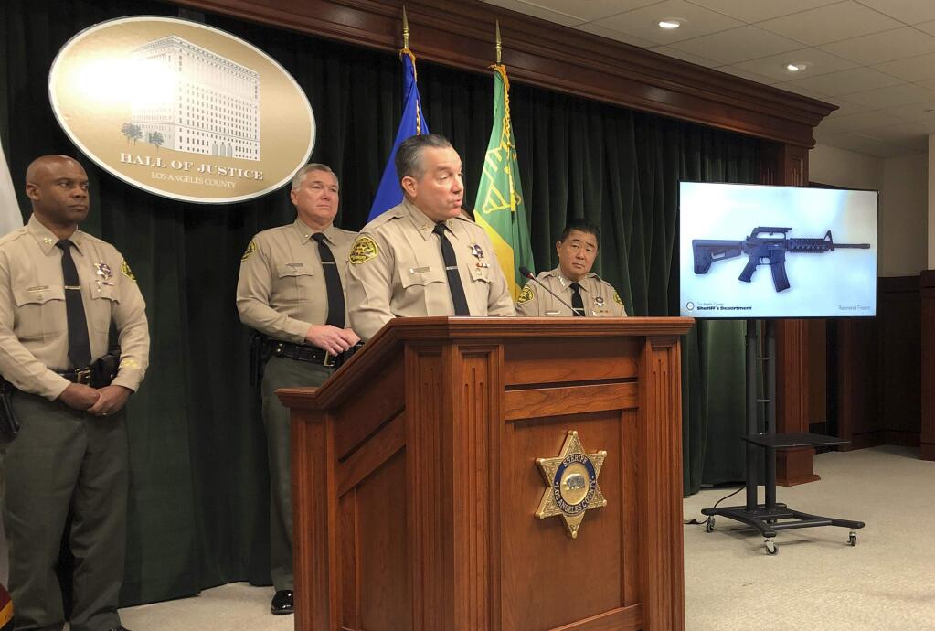 Los Angeles County Sheriff Alex Villanueva, at podium, talks about the arrest of a 13-year-old boy and the seizure of a rifle and ammunition after the teen threatened to shoot other students and staff at his Los Angeles-area middle school, at Sheriff's headquarters in downtown Los Angeles Friday, Nov. 22, 2019. Villanueva said deputies serving a search warrant at the boy's home Thursday discovered an AR-15-style gun, 100 rounds of ammunition, a list of names and a drawing of the school. Villanueva said the boy said he would carry out the shooting Friday at Animo Mae Jemison Charter Middle School in Willowbrook, an unincorporated county area near South Los Angeles. (AP Photo/Brian Melley)