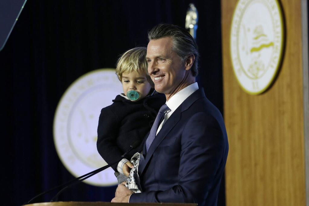 California Governor Gavin Newsom holds his son, Dutch, while speaking during his inauguration Monday, Jan. 7, 2019, in Sacramento, Calif. Newsom has proposed expanding California's paid parental leave program. (AP Photo/Rich Pedroncelli)