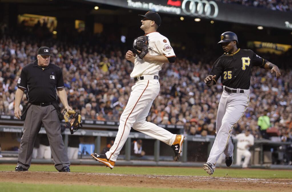 Pittsburgh Pirates' Gregory Polanco, right, scores next to San Francisco Giants pitcher Chris Heston during the third inning of a game Tuesday, June 2, 2015, in San Francisco. Polanco scored on a wild pitch by Heston. Home plate umpire Doug Eddings watches the play. (AP Photo/Ben Margot)