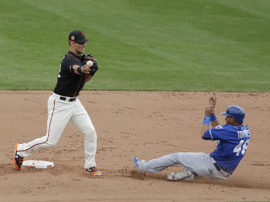 Kansas City Royals' Ramon Torres is forced out at second as San Francisco Giants' Joe Panik throws to first for a double play during the fourth inning of a spring training game, Sunday, March 5, 2017, in Scottsdale, Ariz. (AP Photo/Darron Cummings)