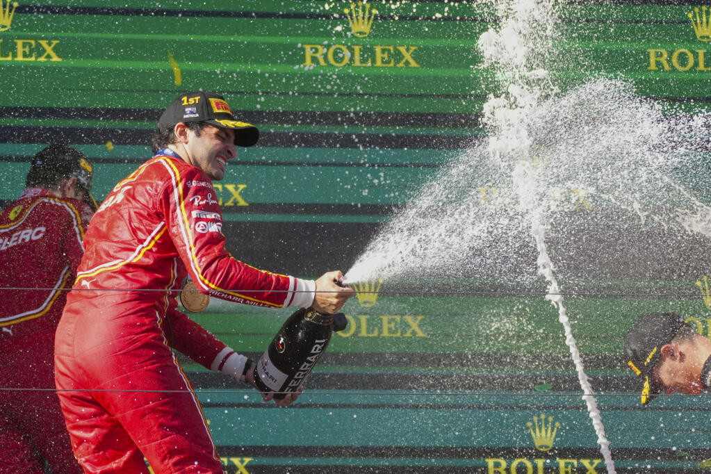 Ferrari driver Carlos Sainz of Spain sprays champagne as he celebrates after winning Sunday’s Australian Formula One Grand Prix at Albert Park, in Melbourne. (Scott Barbour / ASSOCIATED PRESS)
