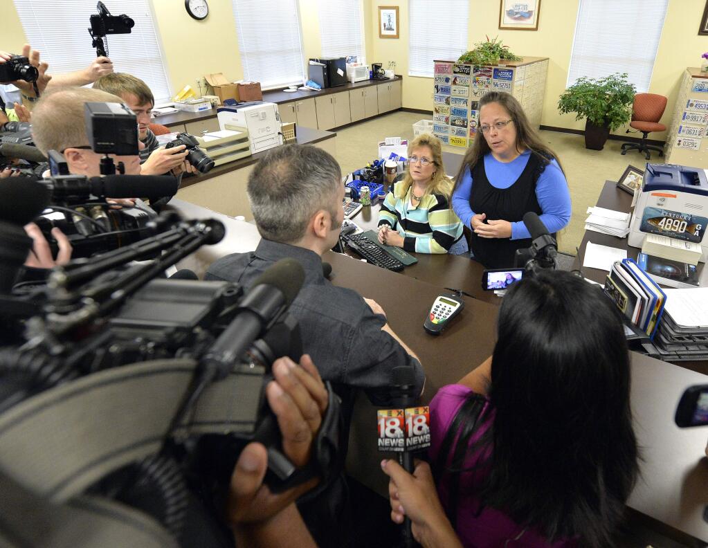 Rowan County Clerk Kim Davis, right, talks with David Moore following her office's refusal to issue marriage licenses at the Rowan County Courthouse in Morehead, Ky., Tuesday, Sept. 1, 2015. Although her appeal to the U.S. Supreme Court was denied, Davis still refuses to issue marriage licenses. (AP Photo/Timothy D. Easley)