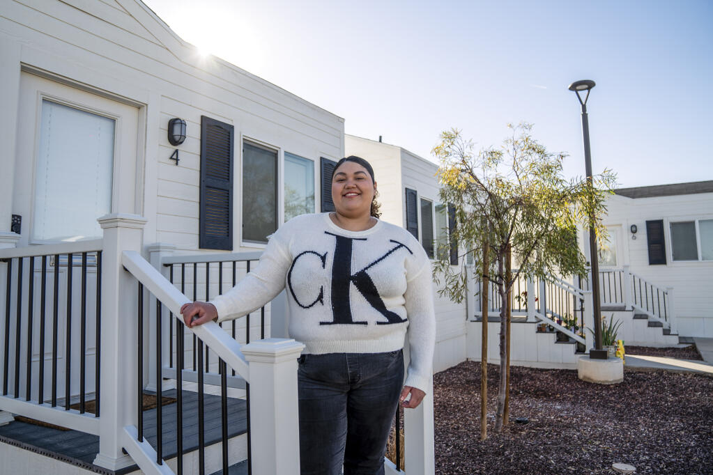 Emily Garcia stands in front of her tiny home at Lotus Living in El Centro on Jan. 22, 2023. The homes were built for housing-insecure students at nearby Imperial Valley College. Photo by Ariana Drehsler for CalMatters