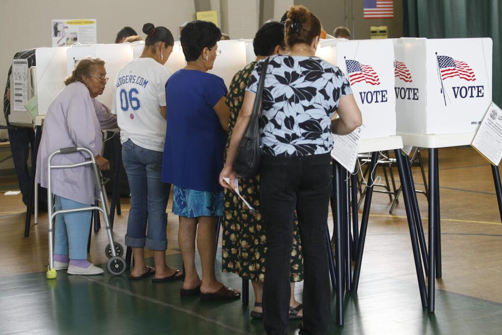 In this June 6, 2006 file photo, people casting their ballot in the California primary election in Los Angeles. With fewer than a fourth of voters showing up for recent local elections, the citys Ethics Commission voted Thursday, Aug. 14, 2014, to recommend that the City Council consider a cash-prize drawing as an incentive to vote. (AP Photo/Damian Dovarganes, File)