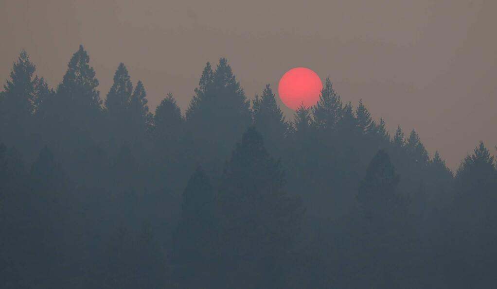 The sun sets over the smoke-filled hills surrounding Laytonville on Sunday, Aug. 10, 2014. (Christopher Chung / The Press Democrat)