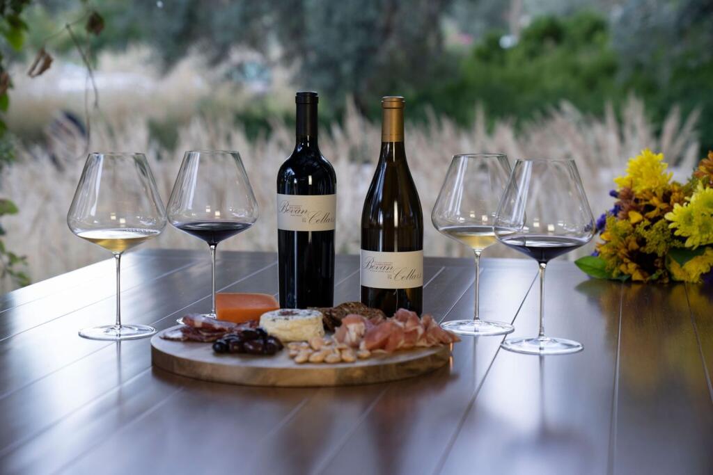 Bevan Cellars wine bottles and glasses with a cutting board covered with appetizers. (Facebook)