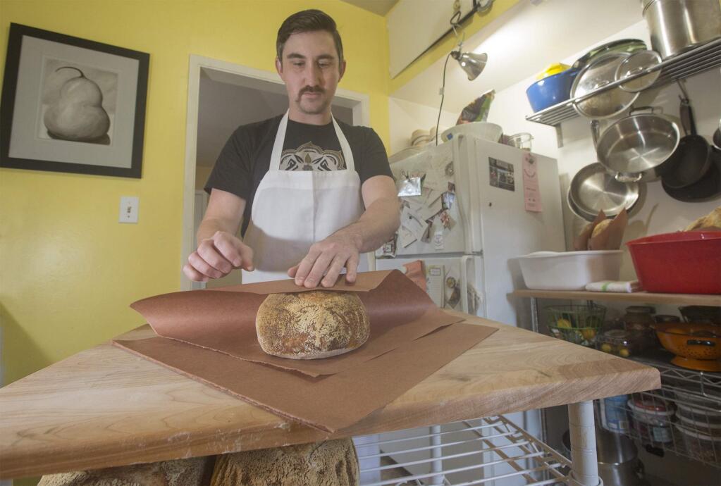 Baker Ian Conover in his home kitchen wrapping freshly made bread for home delivery, a new service in Sonoma. (Photo by Robbi Pengelly/Index-Tribune)