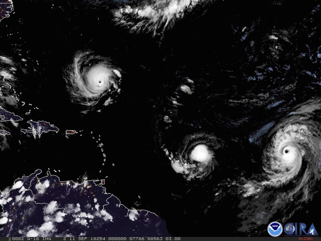 This image provided by NOAA shows Hurricane Florence, third from right, on Tuesday, Sept. 11, 2018, as it threatens the U.S. East Coast. At right is Hurricane Helene, and second from right is Tropical Storm Isaac. (NOAA via AP)