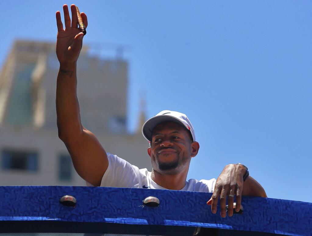 Warriors forward Andre Iguodala waves to the fans, while riding in the team's victory parade in Oakland on Tuesday, June 12, 2018. (Christopher Chung/ The Press Democrat)