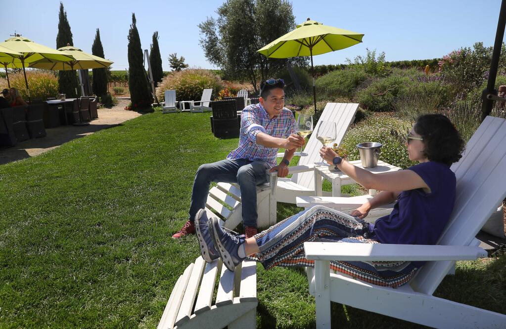 Oscar Patino, left, and Rachel Greif, enjoy a glass of wine at Bouchaine Vineyards, near Napa, during a stop on a vegan tour with La Belle Vie Tours on Friday, August 30, 2019. (Christopher Chung/ The Press Democrat)