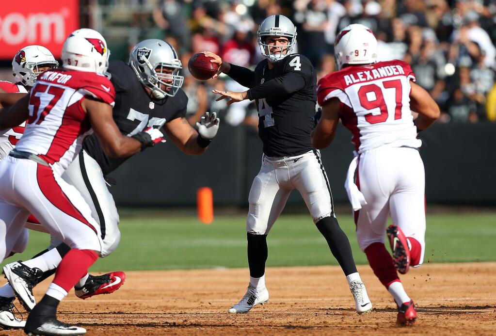 Oakland Raiders quarterback Derek Carr looks for an open receiver against the Arizona Cardinals during their game in Oakland on Sunday, August 30, 2015. (Christopher Chung/ The Press Democrat)