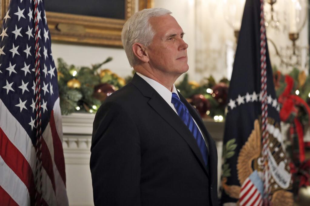 FILE - In this Dec. 6, 2017, file photo, Vice President Mike Pence listens as President Donald Trump speaks in the Diplomatic Reception Room of the White House in Washington. Pence is postponing his trip to Egypt and Israel until the middle of January, citing an upcoming vote in the Senate to overhaul the nation's tax system. (AP Photo/Alex Brandon, File)