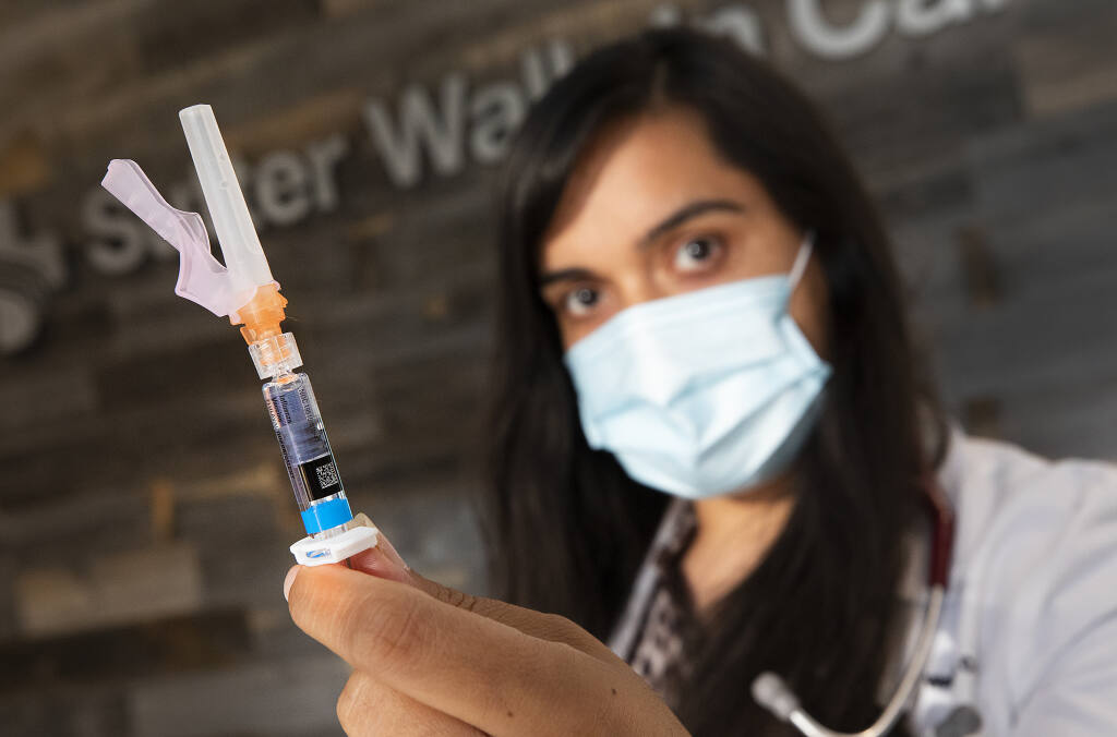 Physician assistant Shivani Vasishta holds a prepackaged syringe with the latest flu vaccine at the Santa Rosa Walk-in clinic on Tuesday, Sept. 15, 2020. (John Burgess / The Press Democrat)